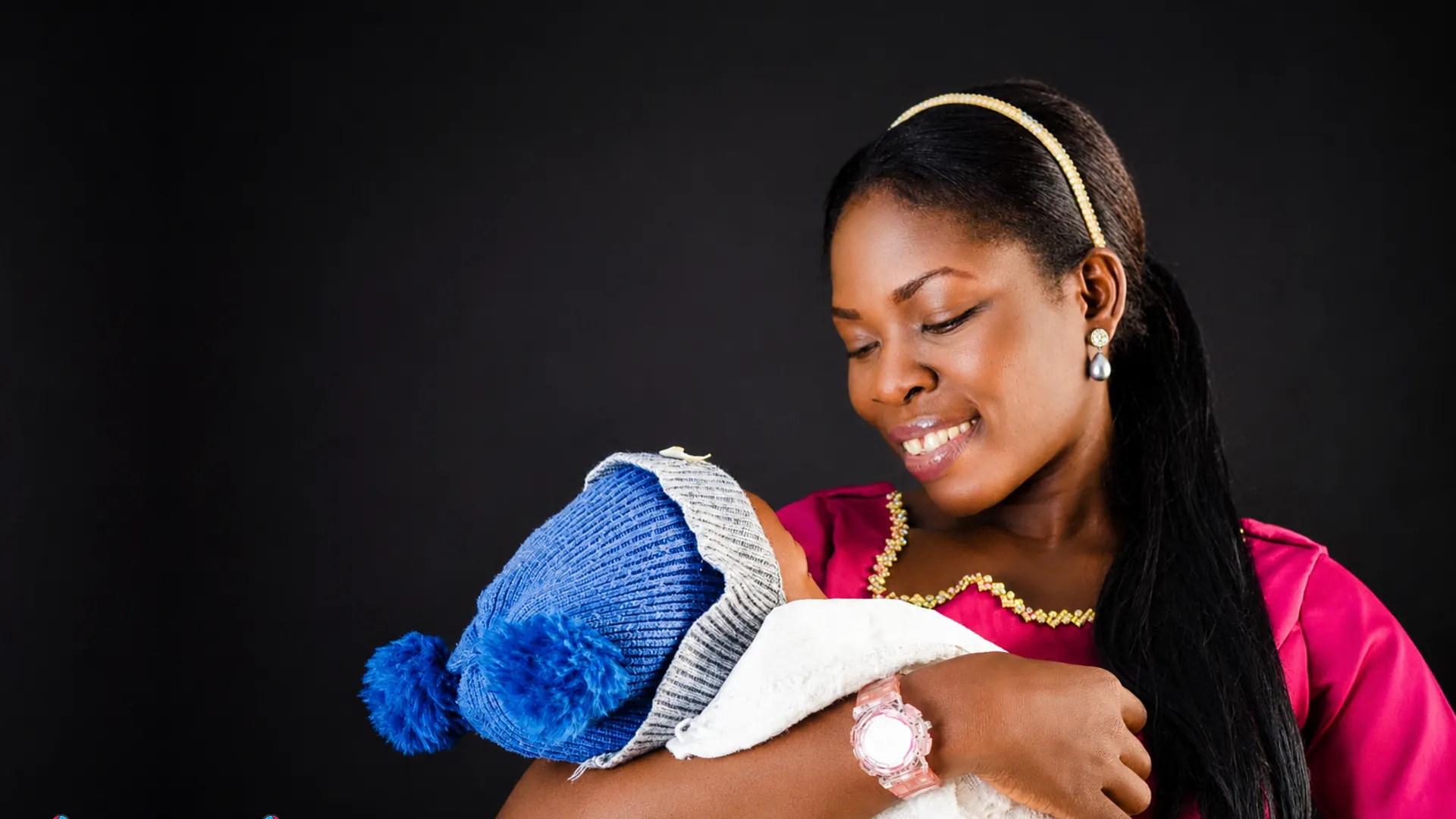 A mother smiling down at the newborn she holds close.